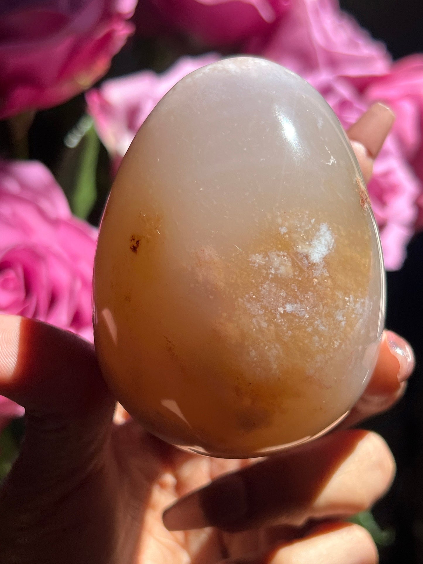 May include: A smooth, light brown agate egg with white and brown inclusions. The egg is polished and has a glossy finish.